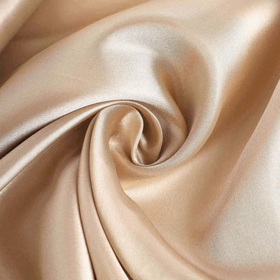 Smooth golden satin fabric swirl showcasing luxurious texture.