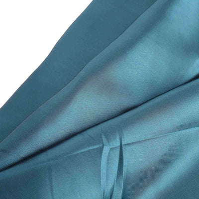 Teal satin fabric draped elegantly, showcasing its smooth texture.