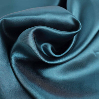 Teal satin fabric with soft folds and a smooth texture.