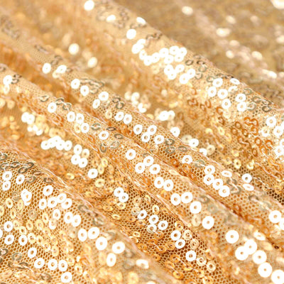 Shimmering gold sequin fabric with a textured surface.