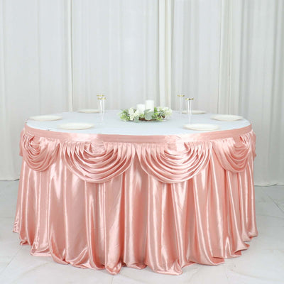 Round table adorned with elegant pink satin tablecloth and decorative centerpiece.