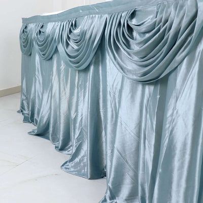 Elegant teal table skirt with draped fabric detail.