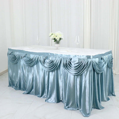 Elegant blue table skirt draping over a banquet table with floral centerpiece.