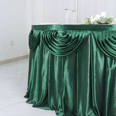 Green satin tablecloth with pleated design draping elegantly.