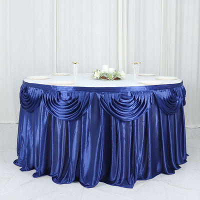 Round table with elegant navy satin tablecloth and decorative draping.