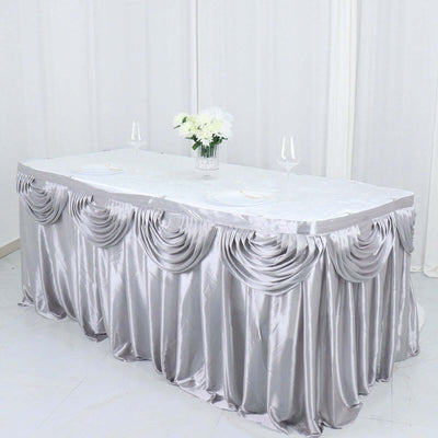 Silver table skirt draped elegantly on a banquet table with floral centerpiece.