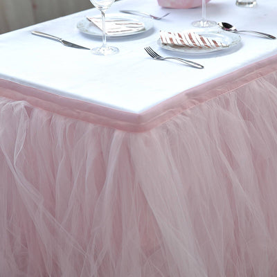 Pink tulle table skirt draping elegantly over a white tablecloth.