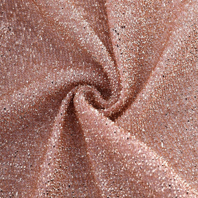 Shimmering rose gold fabric with a textured finish in a swirling pattern.