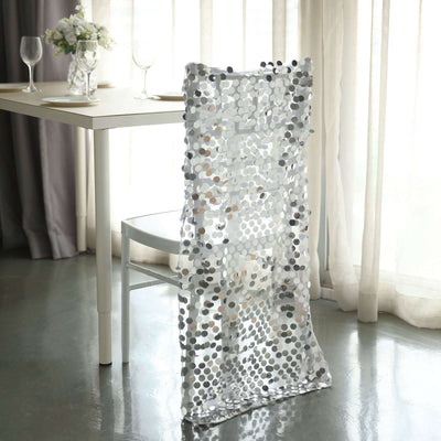 Decorative silver sequin chair cover in a stylish dining setting.