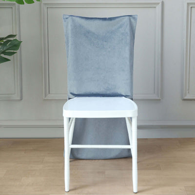 White chair with a gray velvet cover against a plain background.