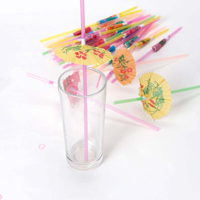 Clear glass with colorful cocktail straws and decorative umbrellas