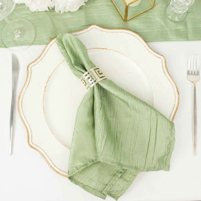 Green silk napkin elegantly arranged on a decorative plate with a napkin ring.