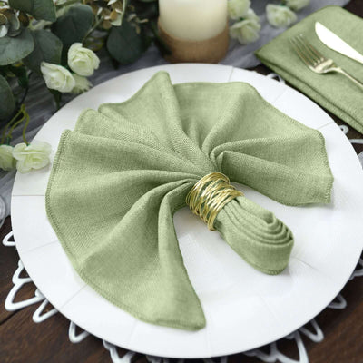 Green napkin elegantly arranged on a plate with a gold napkin ring.