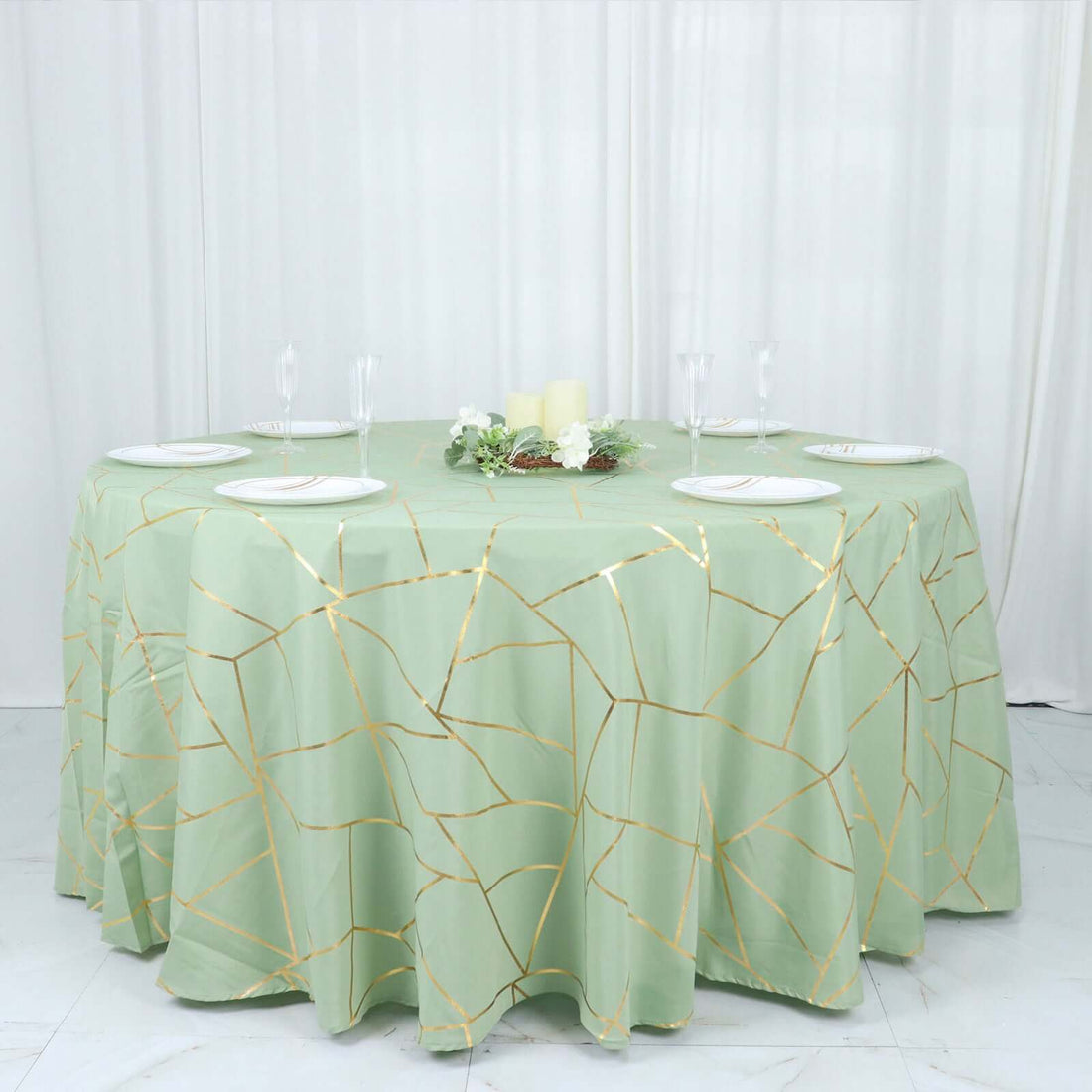 Round green tablecloth with gold geometric design on a banquet table.