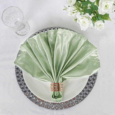 Elegant green napkin elegantly folded on a dinner plate with a decorative ring.