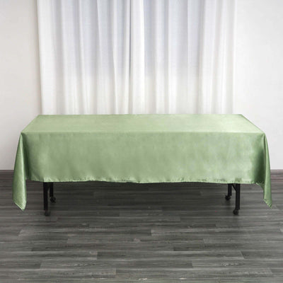Green satin tablecloth on a table against a light backdrop.