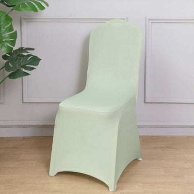 Green chair cover on a wooden floor with plants in the background.