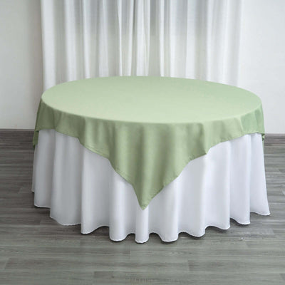 Round table with a green and white tablecloth in a minimalist setting.