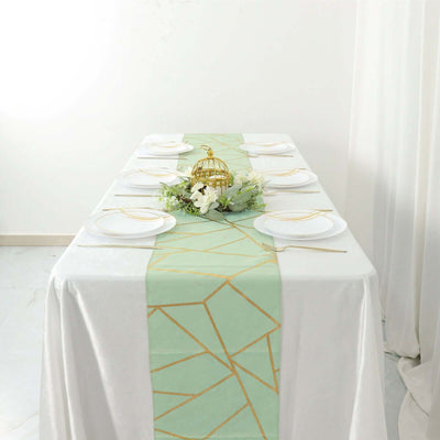 Elegant mint green table runner with gold geometric design on a dining table.