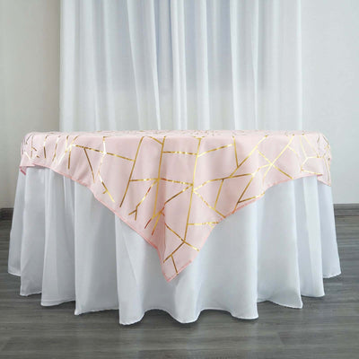 Pink tablecloth with gold geometric pattern on a white table.