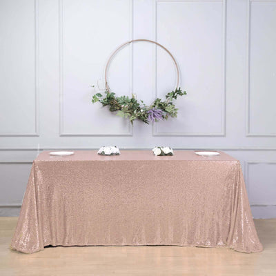 Rose gold sequin tablecloth draped over a table in a styled setting.