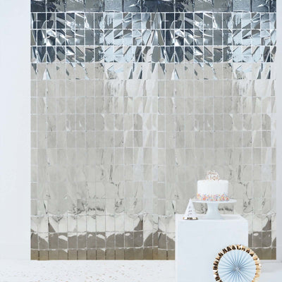 Mirrored tile backdrop with a white cake on a pedestal.