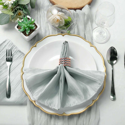 Elegant table setting with silver cutlery and soft gray napkin display.