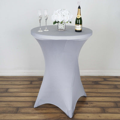 Gray stretch table cover with a round top, champagne, and floral centerpiece.