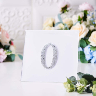 Silver decorative number "0" on a plain white background.