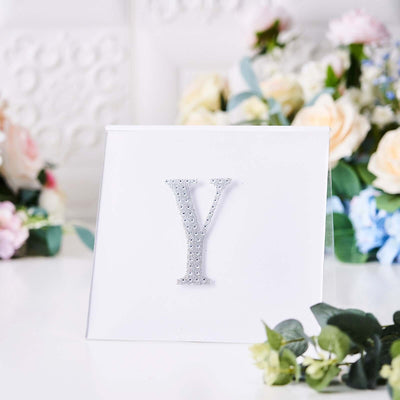 Silver glitter letter "Y" on a white background.