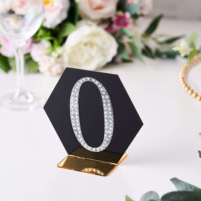 Black hexagon table number '0' with rhinestones on a gold base.