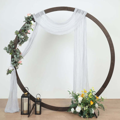 Circular wedding arch with drapery and floral accents.
