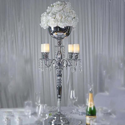 Elegant silver candelabra with white roses and candles on a festive table.