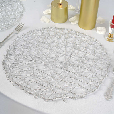 Silver decorative placemat on a table setting with candles and rose petals.