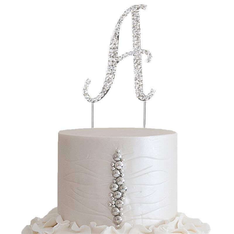 Elegant silver rhinestone letter "A" cake topper on a white cake.