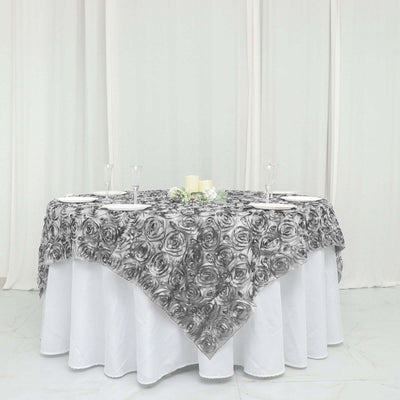Black and white rose-patterned tablecloth draped over a round table.