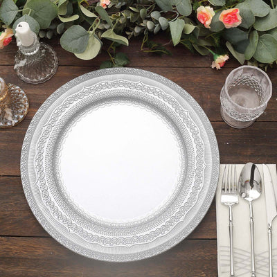 Elegant decorative plate on a wooden table with glassware and cutlery.