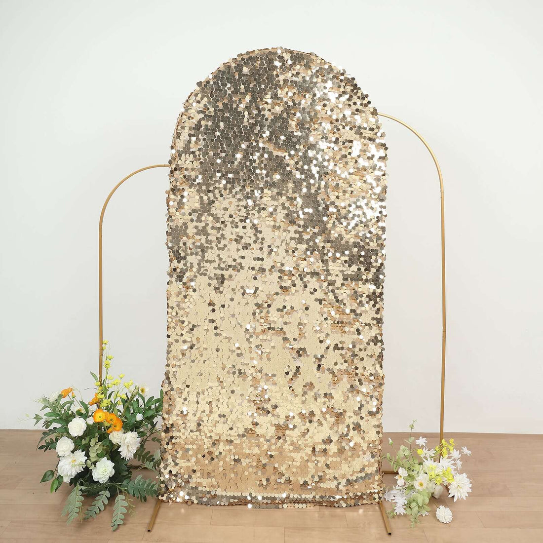 Gold sequin backdrop with floral arrangements, perfect for events and photo shoots.