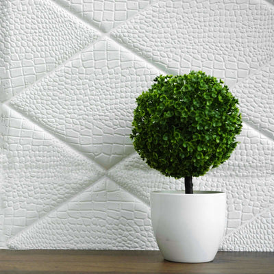 Decorative faux topiary in a white pot on textured white background.