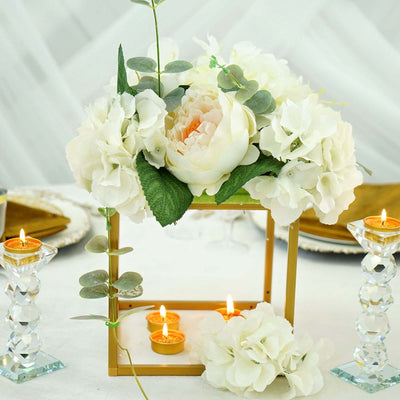 Elegant floral centerpiece with candles on a table setting.