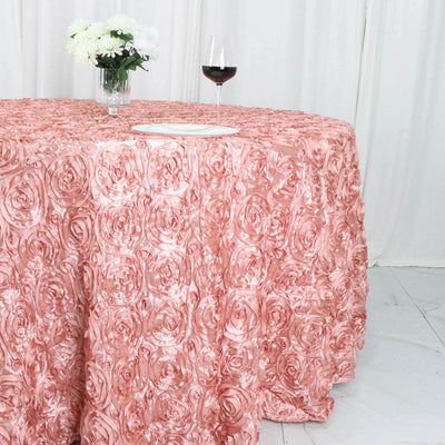 Pink rose-patterned tablecloth draped over a round table with a glass of wine.