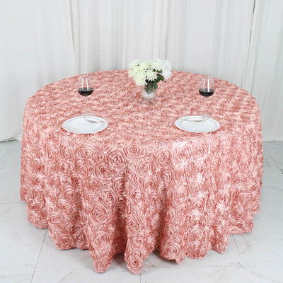 Round rose-patterned tablecloth in soft pink, elegantly draped on a table.