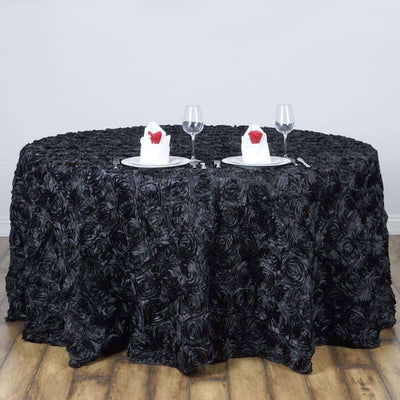 Black rose-patterned tablecloth draped over a round table set for two.