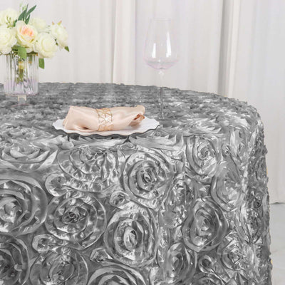 Elegant silver rose-patterned tablecloth with napkin and glass.