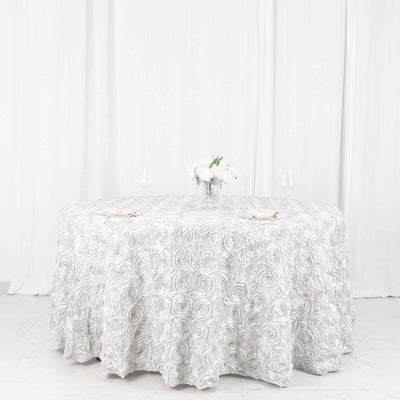 Elegant round table with a textured silver rose tablecloth and floral centerpiece.