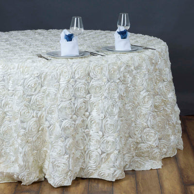 Elegant white rose tablecloth draping a round table set for two.
