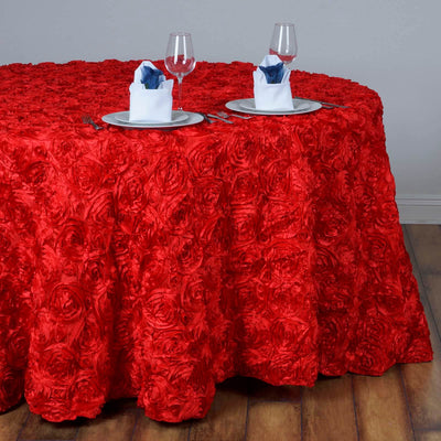 Red rose-pattern tablecloth on a dining table with elegant place settings.