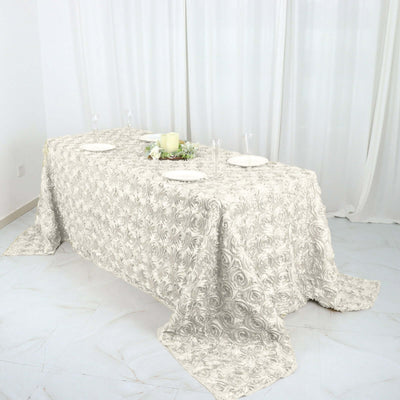 Elegant floral tablecloth draped over a dining table with plates and decor.