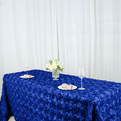 Blue rose-patterned tablecloth with plates and glasses set for dining.