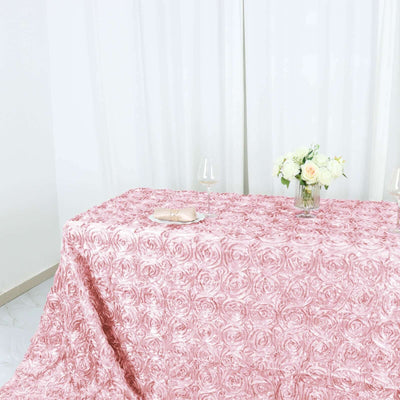 Pink rose-patterned tablecloth on a styled table with floral centerpiece.